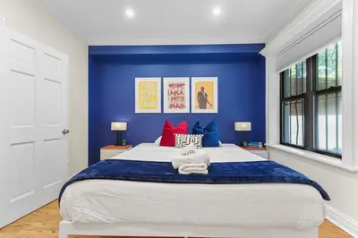 a bedroom with a large bed with blue walls at SWJ544FH Huge 6BR 4BA Backyard Access in New York