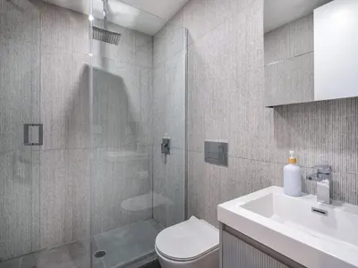 a bathroom with a shower and a toilet and a sink at Three-Bedroom Suite in Prime Williamsburg in Brooklyn