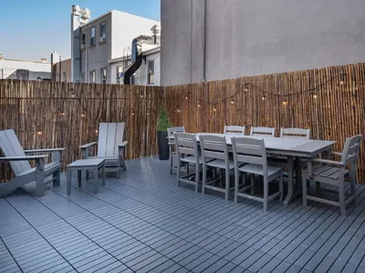 a patio with a table and chairs and a fence at Three-Bedroom Suite in Prime Williamsburg in Brooklyn