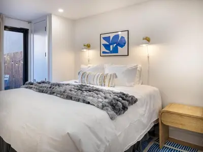 a bedroom with a large white bed and a window at Three-Bedroom Suite in Prime Williamsburg in Brooklyn
