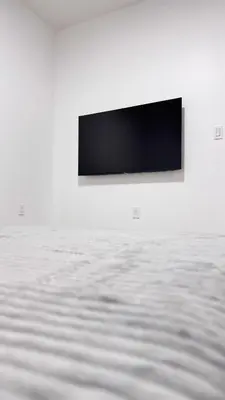 a flat screen tv on a white wall at Beautiful Bedroom with Attached Bathroom, 15 minutes from NYC in West New York