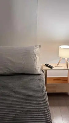a bed with a pillow and a table with a lamp at Beautiful Bedroom with Attached Bathroom, 15 minutes from NYC in West New York