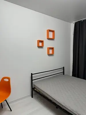 a bedroom with a bed and a orange chair at Chic and Sparkle in Beacon
