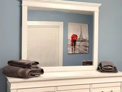 a mirror sitting on top of a dresser in a bathroom at Newly Renovated 2 BR downtown Apt, family getaway. in Montclair