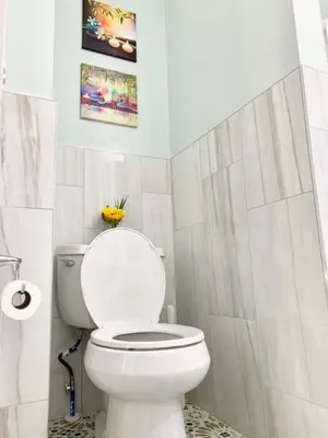 a white bathroom with a toilet and a sink at Newly Renovated 2 BR downtown Apt, family getaway. in Montclair