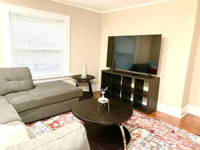 a living room with a couch and a flat screen tv at Newly Renovated 2 BR downtown Apt, family getaway. in Montclair