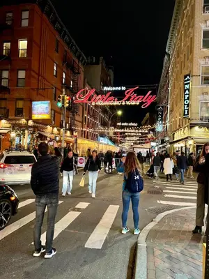 a group of people crossing a busy city street at night at Double Room in New York