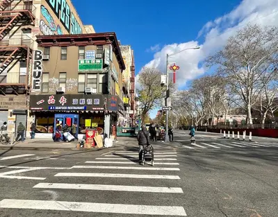 a person with a stroller crossing the street at a crosswalk at Double Room in New York