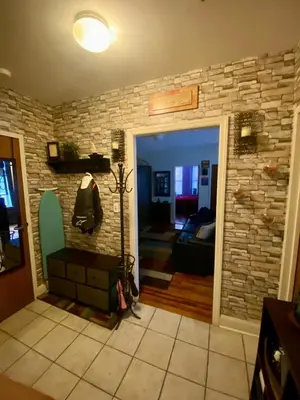 a living room with a stone wall at Woodside room in Sunnyside