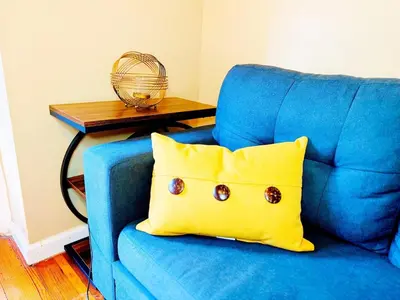 a blue chair with a yellow pillow in a room at NYC 2 Bed America Dream Mall Train Station in Newark