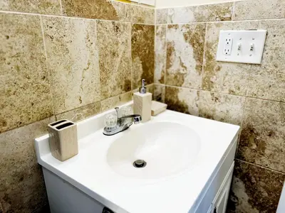 a bathroom with a white sink in a room at NYC 2 Bed America Dream Mall Train Station in Newark