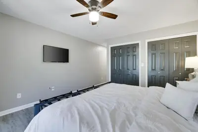 a white bedroom with a bed and a ceiling fan at The Hawley Nook at Lake Wallenpaupack in Hawley