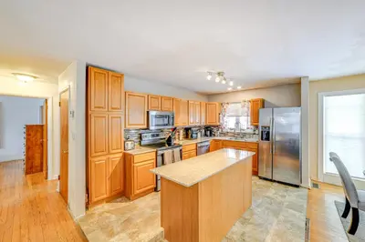 a kitchen with wooden cabinets and stainless steel appliances at 4 Mi to Dtwn Pet-Friendly Home in Utica in Utica