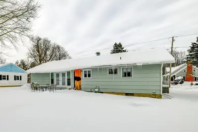 a green house with a snow covered roof at 4 Mi to Dtwn Pet-Friendly Home in Utica in Utica