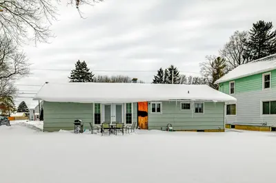a green house with a snow covered roof at 4 Mi to Dtwn Pet-Friendly Home in Utica in Utica