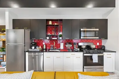 a kitchen with stainless steel appliances and red tile at 4BR Duplex, Prime Location in Newark