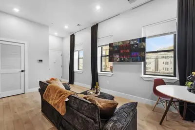 a living room with a couch and a table at 4BR Duplex, Prime Location in Newark