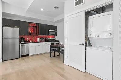 a kitchen with white cabinets and a white refrigerator at 4 Suites Near Downtown Newark in Newark