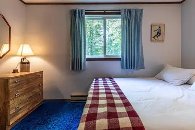 a bedroom with a bed and a window at Retro Retreat Charming Home with Hot Tub & Fire Pit in Rensselaer