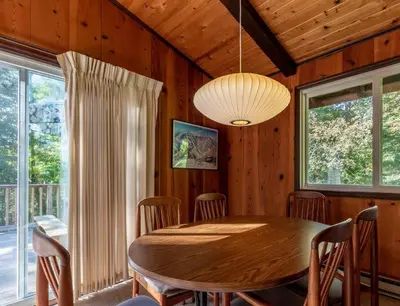 a dining room with a wooden table and chairs at Retro Retreat Charming Home with Hot Tub & Fire Pit in Rensselaer