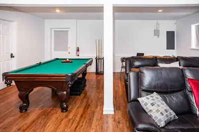a living room with a pool table and a leather couch at Spacious 3BR House, Hot Tub, Firepit, Ski Access! in Emerald Lakes