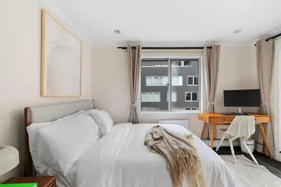 a bedroom with a bed and a desk with a computer at Chelsea Vista II by Rove Travel 2BR PH with Rooftop in New York