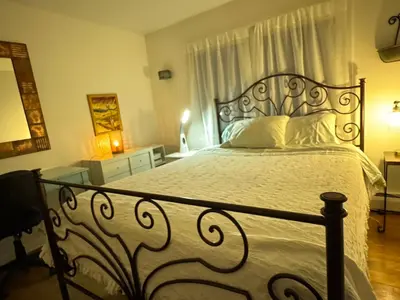 a bedroom with a large bed with a white comforter at Spacious Room with a View of the Woods in Armonk