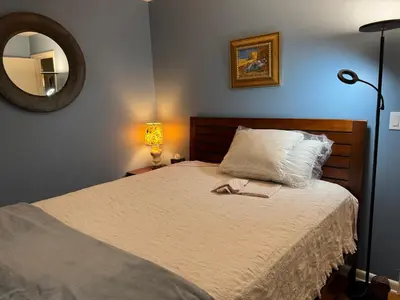 a bedroom with a bed with a mirror on the wall at Spacious Room with a View of the Woods in Armonk