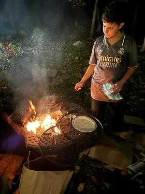 a young boy standing next to a grill at Spacious Room with a View of the Woods in Armonk