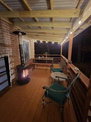 a screened porch with a fireplace and a table and chairs at Spacious Room with a View of the Woods in Armonk