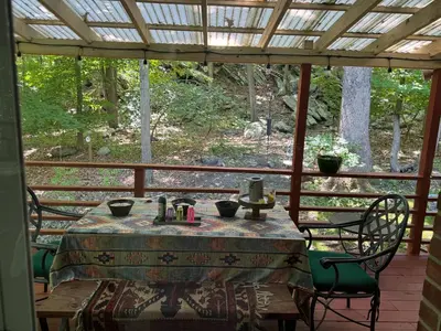 a table and chairs sitting on a porch at Spacious Room with a View of the Woods in Armonk