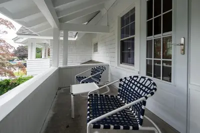 a porch with two blue chairs and a table at Beechmont-Charming Colonial for Events and Getaways! in Bridgeport