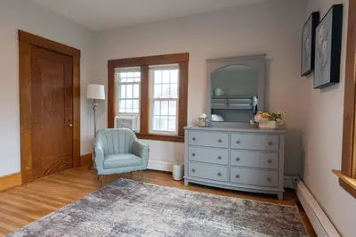 a bedroom with a dresser and a chair and a mirror at Beechmont-Charming Colonial for Events and Getaways! in Bridgeport