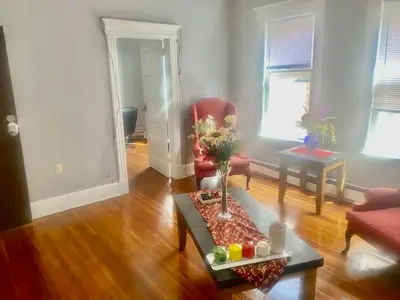 a living room with a red chair and a table at SouthGreen APT 2S in Hartford
