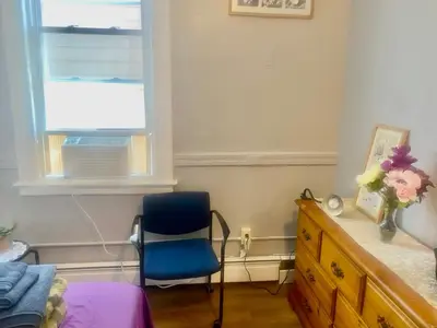 a bedroom with a blue chair and a window at SouthGreen APT 2S in Hartford