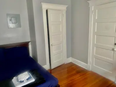a room with two white doors and a blue couch at SouthGreen APT 2S in Hartford