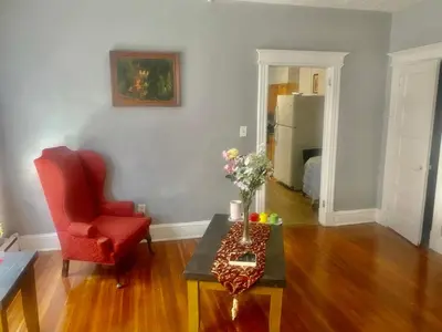 a living room with a red chair and a table at SouthGreen APT 2S in Hartford