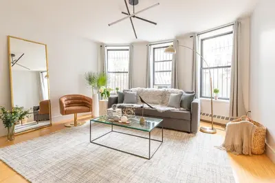 a living room with a couch and a table at Cypress Court I by Rove Travel 2BR Harlem Apartment in New York