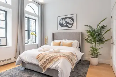 a bedroom with a bed with two stuffed animals on it at Cypress Court I by Rove Travel 2BR Harlem Apartment in New York