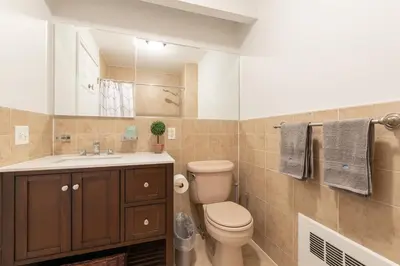 a bathroom with a toilet and a sink at Cypress Court I by Rove Travel 2BR Harlem Apartment in New York