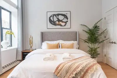 a bedroom with a bed with towels on it at Cypress Court I by Rove Travel 2BR Harlem Apartment in New York