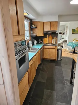 a kitchen with wooden cabinets and a stove top oven at New- Farm view-Winter escape with cozy fireplace in Lake Katrine