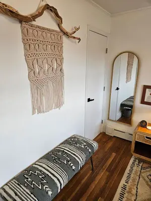 a room with a bed and a mirror on the wall at New- Farm view-Winter escape with cozy fireplace in Lake Katrine