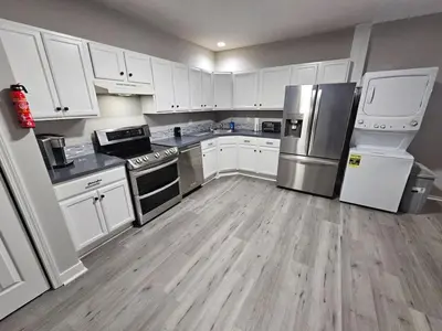 a kitchen with white cabinets and stainless steel appliances at Private Apartment in Southbury 103 in Southbury