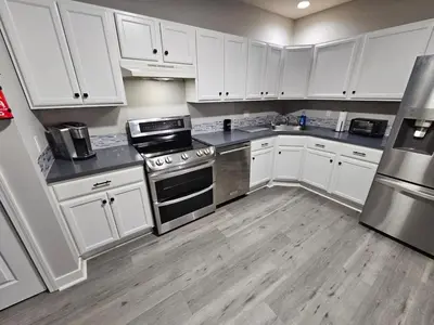 a kitchen with white cabinets and stainless steel appliances at Private Apartment in Southbury 103 in Southbury