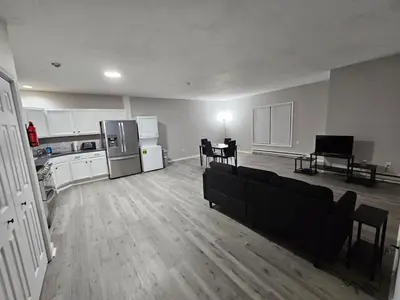 an empty kitchen and living room with a couch and a piano at Private Apartment in Southbury 103 in Southbury