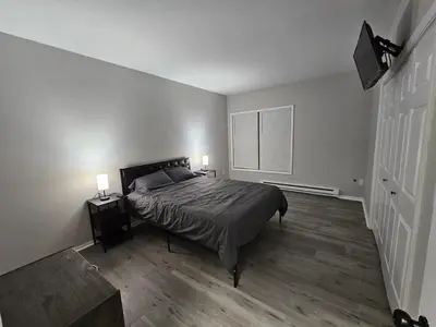 a bedroom with a bed and two night stands and two lamps at Private Apartment in Southbury 103 in Southbury