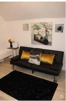 a black couch with gold pillows in a living room at Keri APRN LLC in Ansonia