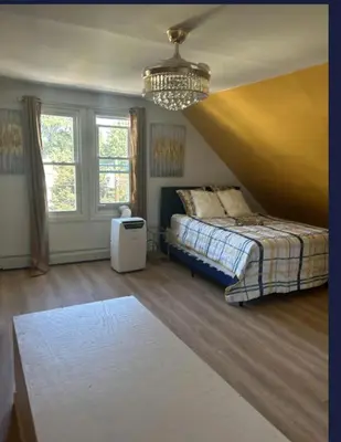 a bedroom with a bed and a chandelier at Keri APRN LLC in Ansonia
