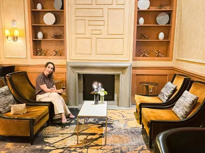 a woman sitting in a room with a fireplace at Executive Hotel Le Soleil New York in New York